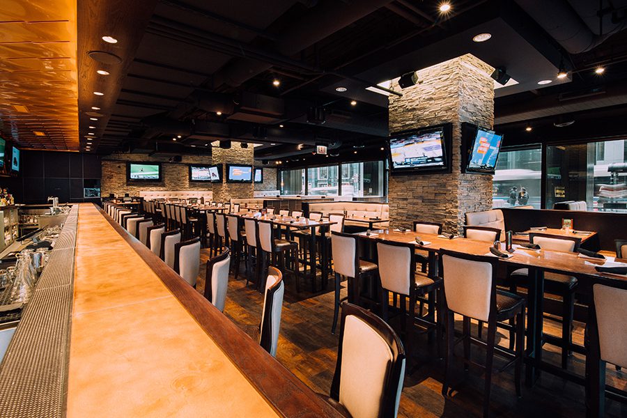 The Sweetwater main long bar, showing plenty of bar seating and some mounted televisions