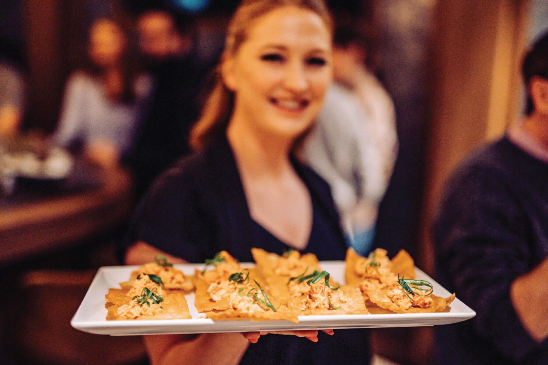 Female server holding a platter of food